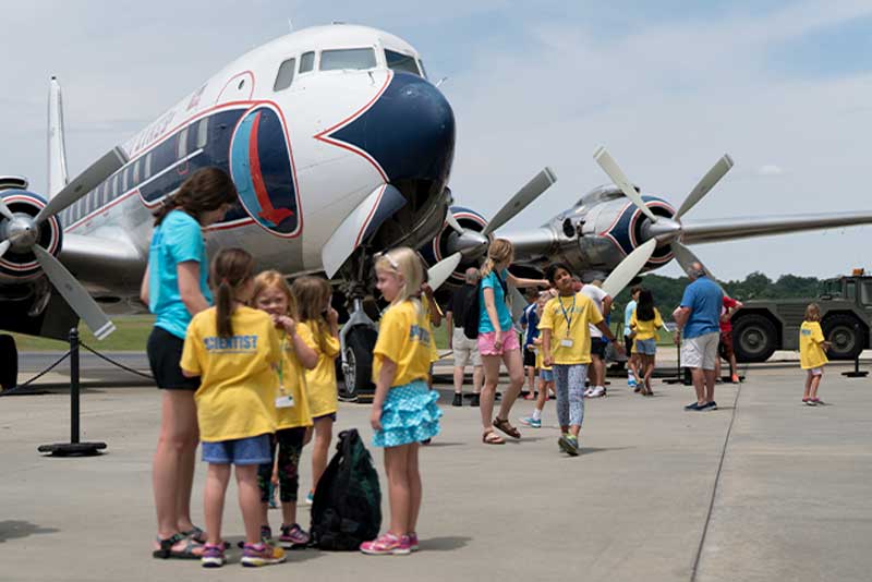 Kids on a field trip sitting in a museum airplane